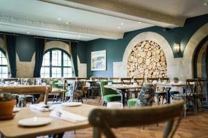 a restaurant with tables and chairs and a wall of windows at The Bear Of Rodborough Hotel in Stroud