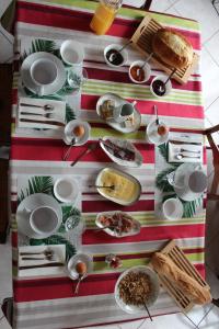 een tafel met borden en borden op een gestreepte tafeldoek bij Au Coeur du Bocage Vendéen in Chantonnay