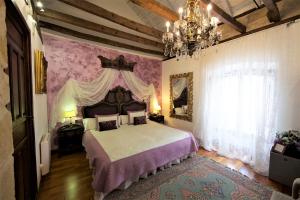 ein Schlafzimmer mit einem großen Bett und einem Kronleuchter in der Unterkunft Hotel Boutique Nueve Leyendas in Úbeda