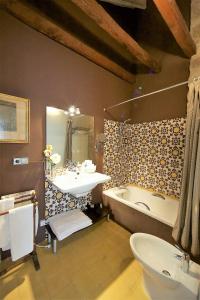 
a bathroom with a sink, toilet and bathtub at Hotel Boutique Nueve Leyendas in Úbeda
