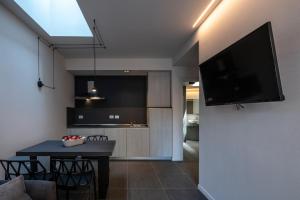 salon ze stołem i telewizorem na ścianie w obiekcie Astoria Boutique Apartments w Bolonii
