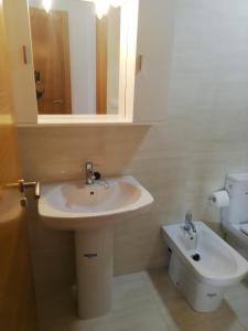 a bathroom with a sink and a toilet at PISO COLLAZO in Isla de Arosa +49 photos