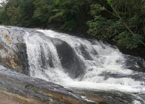 a waterfall on the side of a river at CASA - CIDADE das CACHOEIRAS in Santa Rita de Jacutinga