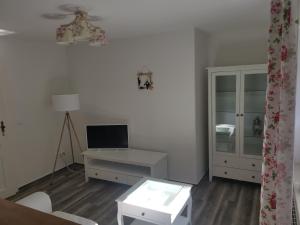 a living room with a tv and a table and a desk at Wiesenblick in Dönschten