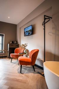 a living room with two chairs and a table at Harbour Suites Boutique Hotel in Monnickendam