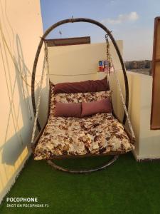 a swing bed in the corner of a room at شقة كلاسيك بمساحة خضراء قريبة من الحصري in 6th Of October