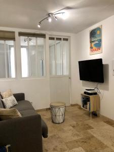 a living room with a couch and a flat screen tv at mourillon in Toulon