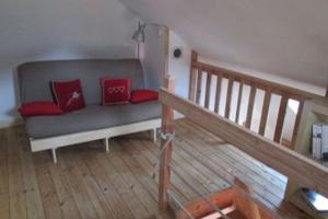 salon z szarą kanapą i czerwonymi poduszkami w obiekcie Les Thures Hameau du Roubion Hautes Alpes w mieście Névache