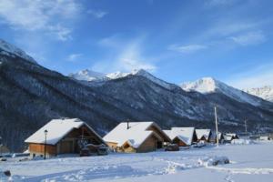 grupa domków w śniegu z górami w obiekcie Les Thures Hameau du Roubion Hautes Alpes w mieście Névache