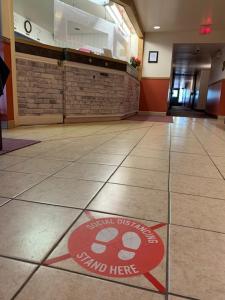 a red and white sign is on the floor at Redwood Motor Inn in Brandon