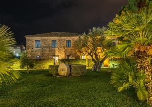 a large stone building at night with palm trees at Rada Siri in Montepaone