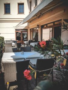 an outdoor patio with tables and chairs and flowers at Restaurant Pansion Wien in Čierny Brod