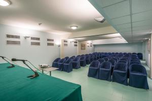 a conference room with blue chairs and a green table at Rada Siri in Montepaone