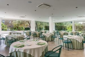une salle de banquet avec tables et chaises et nappes blanches dans l'établissement Rada Siri, à Montepaone