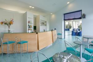 a restaurant with a bar with blue chairs and tables at Rada Siri in Montepaone