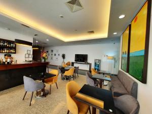 un bar con sillas y mesas en una habitación en BejaParque Hotel, en Beja