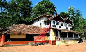 ein Haus mit einer roten Treppe davor in der Unterkunft Balekhan Homestay - Heritage & Mountain View in Chikmagalur