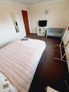 a hotel room with a bed and a television at 4 Bedroom Thundersley Apartment in Rayleigh +2 photos