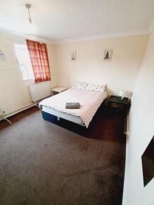 a small bedroom with a bed and a window at 4 Bedroom Thundersley Apartment in Rayleigh