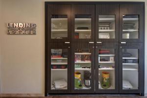 a wooden cabinet with glass doors in a room at Candlewood Suites St Clairsville Wheeling Area by IHG in Saint Clairsville