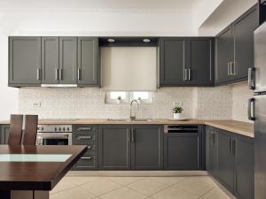 a kitchen with dark gray cabinets and a sink at Aerial View Villas in Lithakia