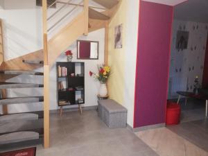 a living room with a staircase and a vase of flowers at Le paradis des caves in Châteauvieux