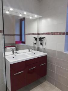 La salle de bains est pourvue d'un lavabo blanc et d'un miroir. dans l'établissement Le paradis des caves, à Châteauvieux
