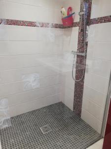 La salle de bains est pourvue d'une douche et de carrelage. dans l'établissement Le paradis des caves, à Châteauvieux