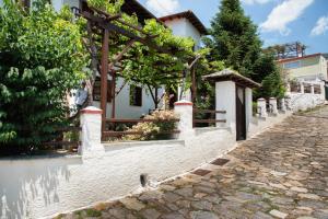 a house with a fence and a cobblestone street at Elatos Country House in Portaria