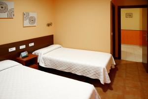 a room with two beds in a hotel room at Alojamiento Numancia Pensión in Burgos
