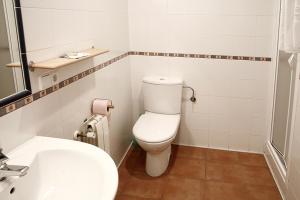 ein weißes Bad mit einem WC und einem Waschbecken in der Unterkunft Alojamiento Numancia Pensión in Burgos