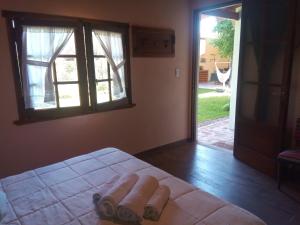 1 dormitorio con cama, ventana y puerta en La Posada de Don Segundo en San Antonio de Areco