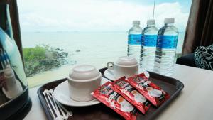 a tray with cups and water bottles on a table at J.G. Resort in Pengerang