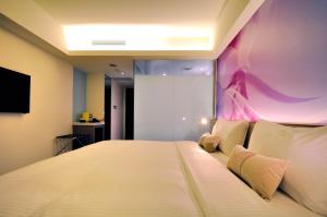 1 dormitorio con 1 cama grande y pared morada en Audi Garden Business Hotel en Taoyuan