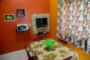 ein Esszimmer mit Tisch und Fernseher in der Unterkunft CABANAS PARA ALUGUEL de TEMPORADA EM BOMBINHAS perto da praia in Bombinhas