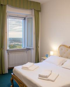 a bedroom with a bed with a large window at Hotel Panorama in Bertinoro