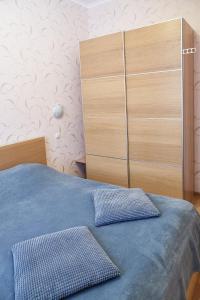 um quarto com uma cama azul e uma cómoda em J&N APARTMENTS Ленинградский em Vyborg