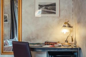 a desk with a lamp and a mirror at B&B Marranzano in Giardini Naxos