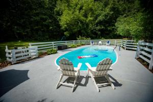 a swimming pool with two chairs and a table at Arcady Mountain Motor Lodge in Sunderland