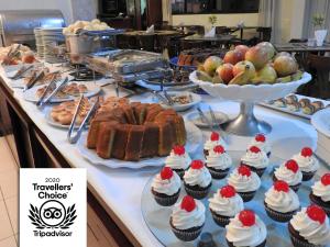 um buffet com bolos e queques numa mesa em Executive Inn Hotel em Uberlândia
