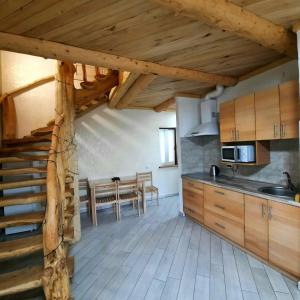 eine Küche mit Holzschränken und einem Tisch im Zimmer in der Unterkunft Vovna in Tatariw
