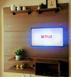 a flat screen tv on a wall in a living room at Apto 2 quartos em Arroio do Silva in Arroio do Silva