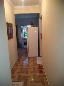 een hal met een witte koelkast en een houten vloer bij Casa familiar in Angra dos Reis