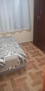 een kamer met een bed en een houten vloer bij Casa familiar in Angra dos Reis