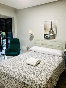 a bedroom with a bed and a green chair at Rooms Suite Planetario in Madrid