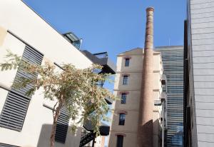 Beach Loft Duplex في برشلونة: مبنى امامه مدخنه وشجر