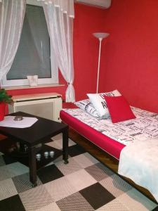 a red room with a bed and a table at Studio Gizella in Budapest