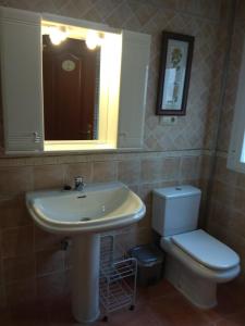 een badkamer met een wastafel, een toilet en een spiegel bij ARCO DE VILLALAR in Baeza