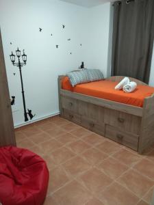 een slaapkamer met een bed met oranje lakens en een lamp bij ARCO DE VILLALAR in Baeza
