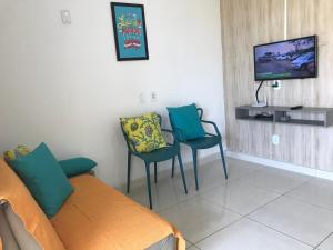 sala de estar con sofá, 2 sillas y TV en Apto Cumaru 150m Do Mar Com Piscina en Praia do Frances